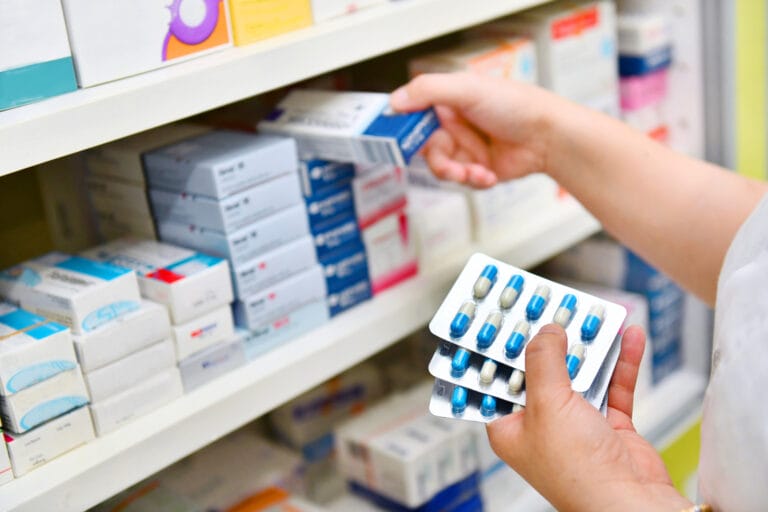 Pharmacist,Holding,Medicine,Box,And,Capsule,Pack,In,Pharmacy,Drugstore.