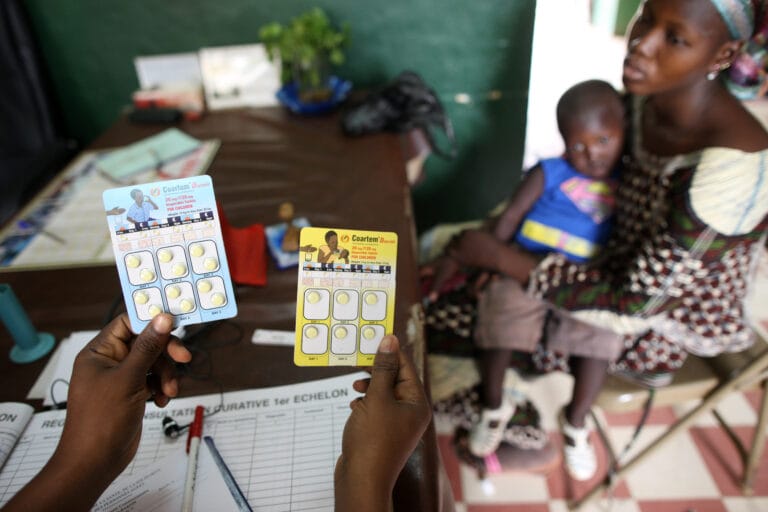 Editorial use only Malaria treatment. Doctor showing a mother packets of antimalarial drugs for treatment of her son. These tables contain the drugs artemether and lumefantrine, which are used to treat multi-drug resistant strains of malaria caused by the parasite Plasmodium falciparum. Photographed in Mali.