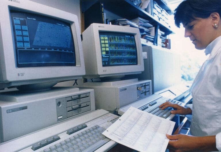 scientist looking at lots of data on multiple computers
