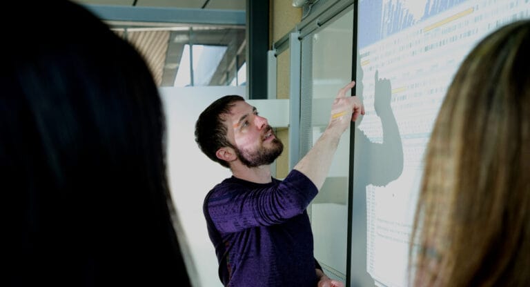 Someone discussing sequencing on a screen projected on the wall