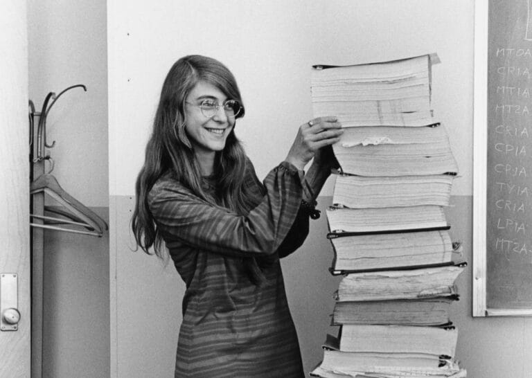 black and white photo of Margaret Hamilton stacking books