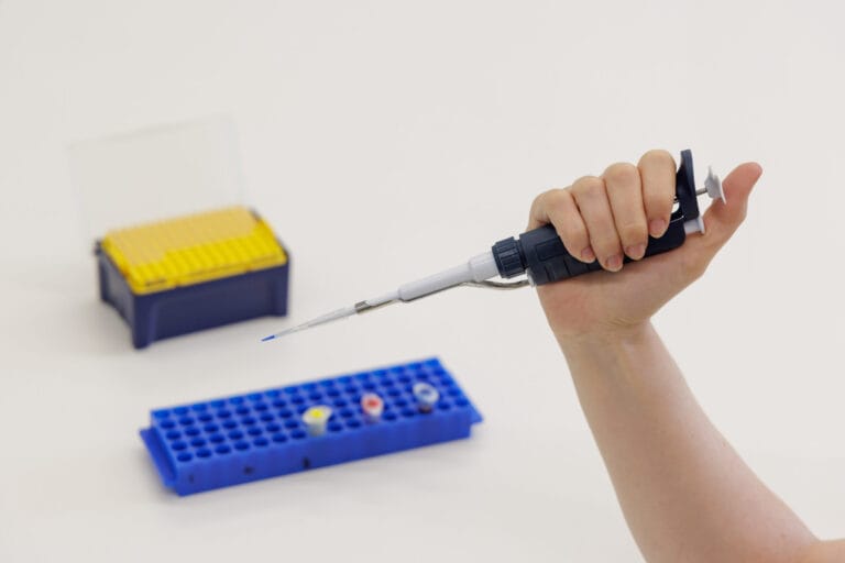 A hand holding a micropipette
